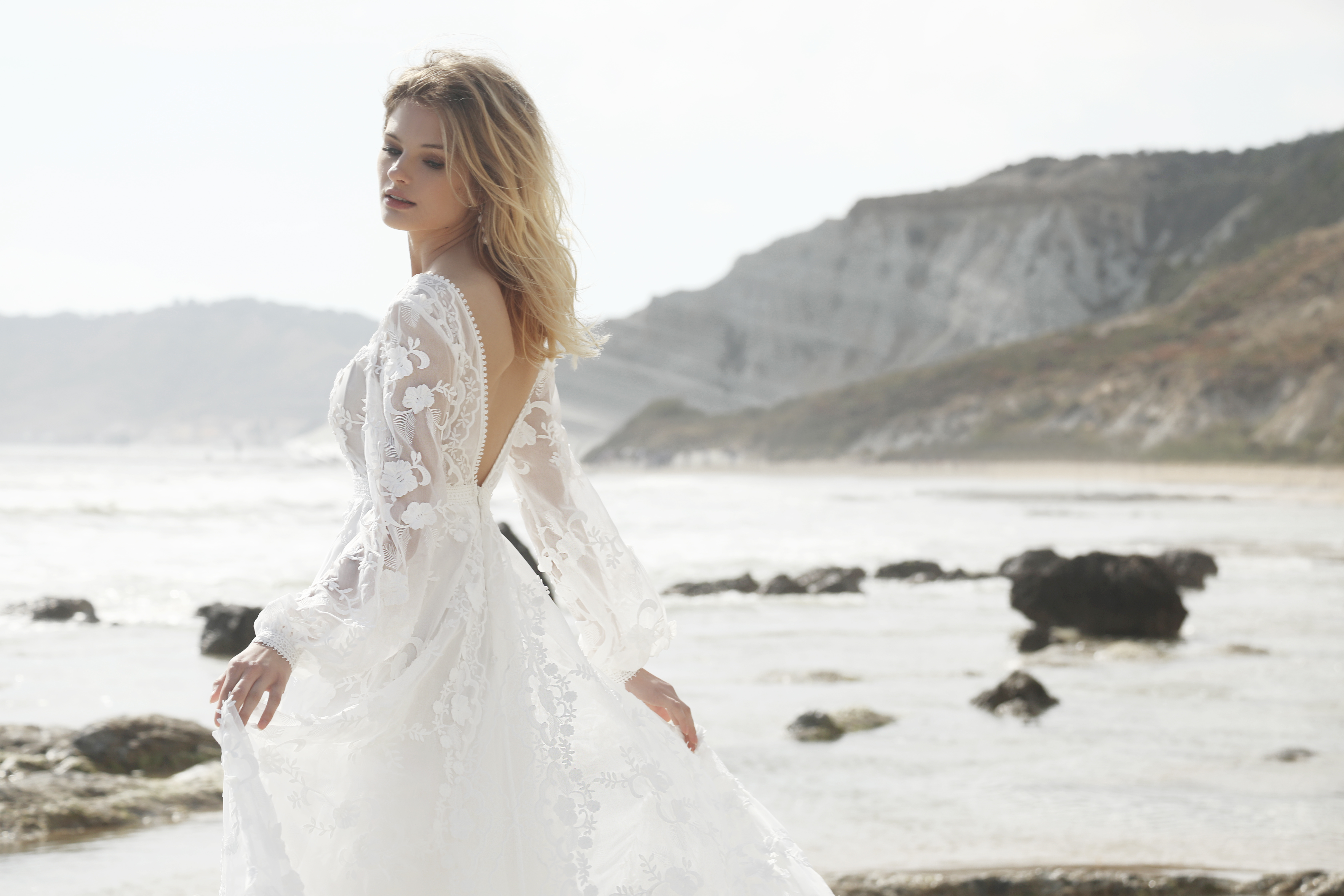 Frau am Meer in einem schönen weißen Hochzeitskleid.