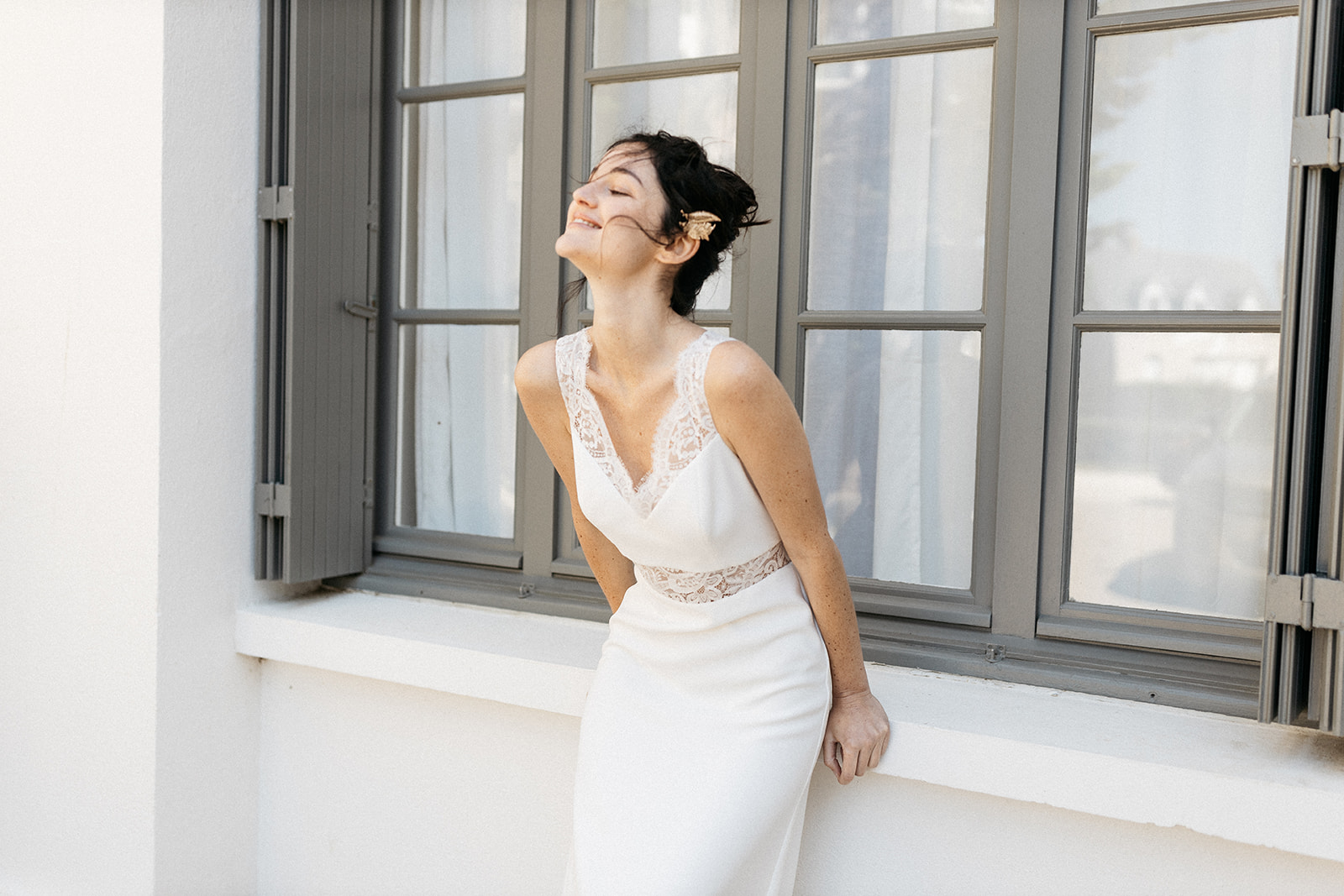 Outlet Slider Lachende Frau im Brautkleid vor einem Fenster