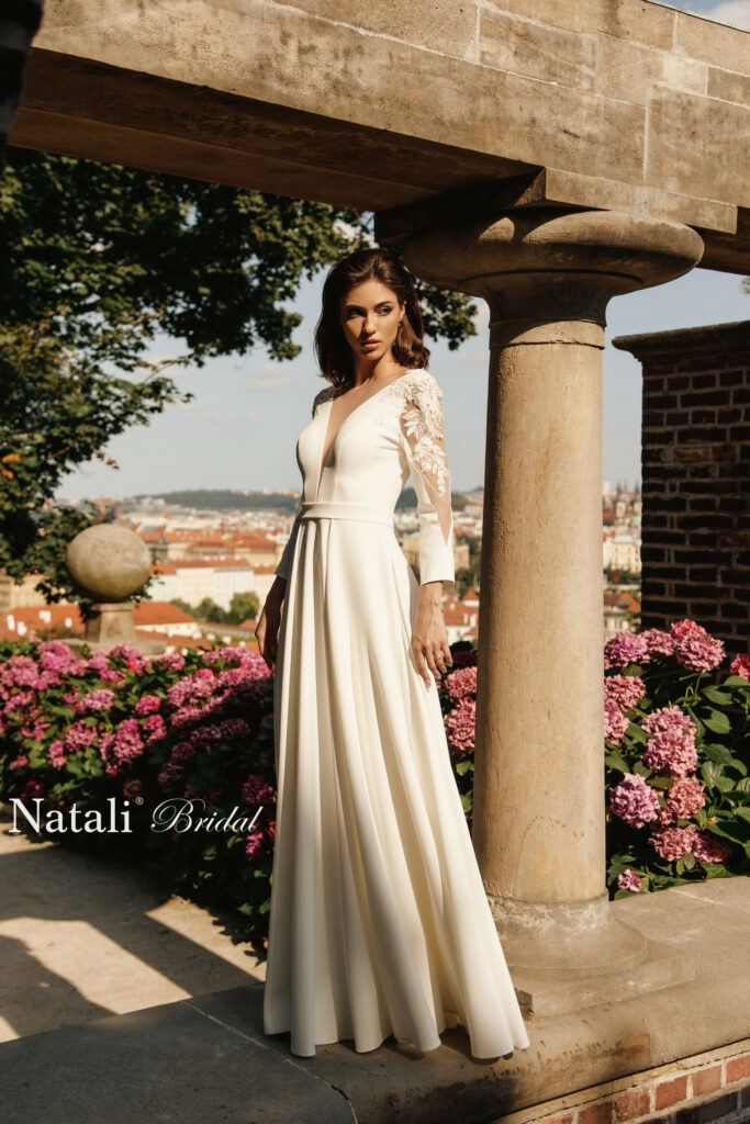 Natali Bridal Hochzeitskleid aus der LISA Kollektion mit einem Rosenbusch im Hintergrund