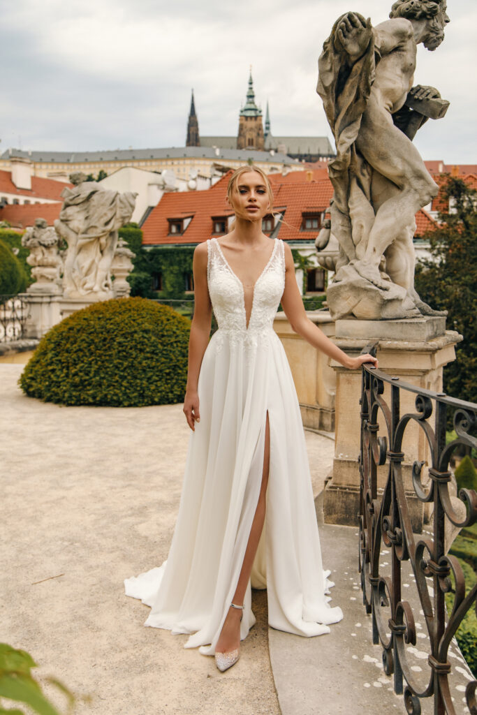 Brautkleid aus der MIRAM Kollektion von vorne vor einer Steinstatue